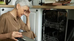 Vrouw met kapotte afwasmachine