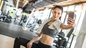 Young sportswoman taking selfie after sports training in gym