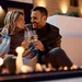 Man en vrouw proosten bij de buitenhaard.