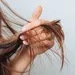 Vrouw houdt gespleten haarpunten in haar hand