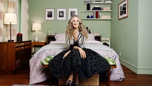 Promobeeld SATC met Sarah Jessica Parker als Carrie Bradshaw in haar slaapkamer. – Jimmy Choo lanceert archiefcollectie met favorieten Carrie Bradshaw.