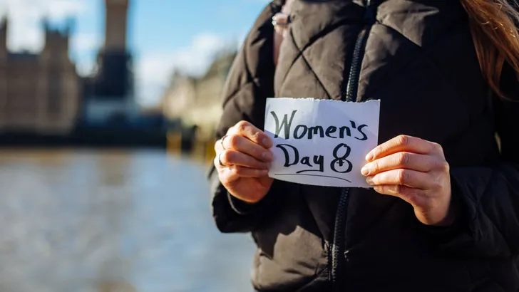 Woman with a note with the text women's day