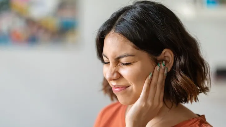 Sick young arab woman having ear pain at home