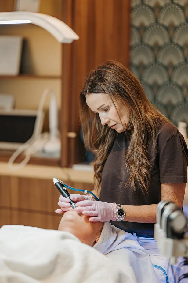 Lies behandelt een cliënt in haar salon met producten van ZO Skin Health.