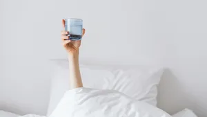 Vrouw met een glas water na het ontwaken met een flinke kater na het kerstfeest.