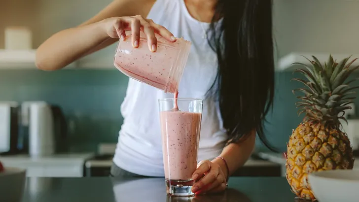 Woman preparing fresh fruit smoothie