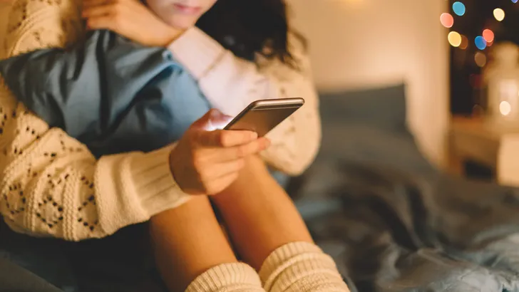 Girl in bed using phone