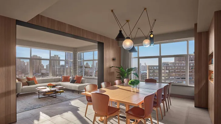 Foto van hotelkamer in ModernHaus SoHo met de skyline van New York zichtbaar door de ramen.