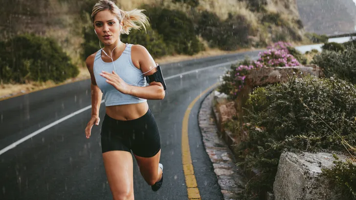 Female athlete running outdoors on highway