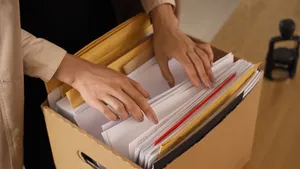 Ter illustratie: vrouw bladert door dossiers.