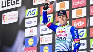 Remco Evenepoel lacht als een boer met kiespijn op het podium in Luik-Bastenaken-Luik.