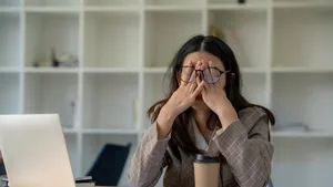 Foto van vrouw achter bureau. – Gevolgen van hele dag zitten voor je billen