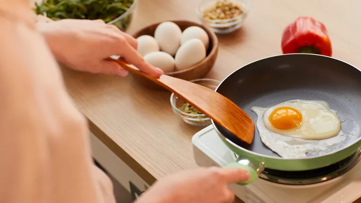 Woman Frying Eggs for Breakfast