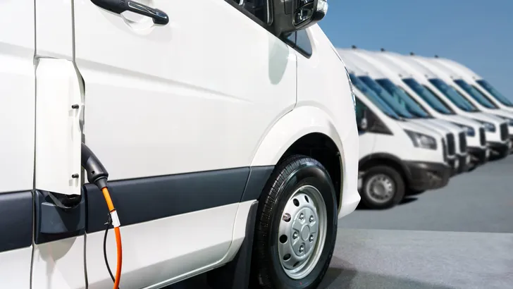 Elektrische bestelwagens staan in een rij bij een laadpunt