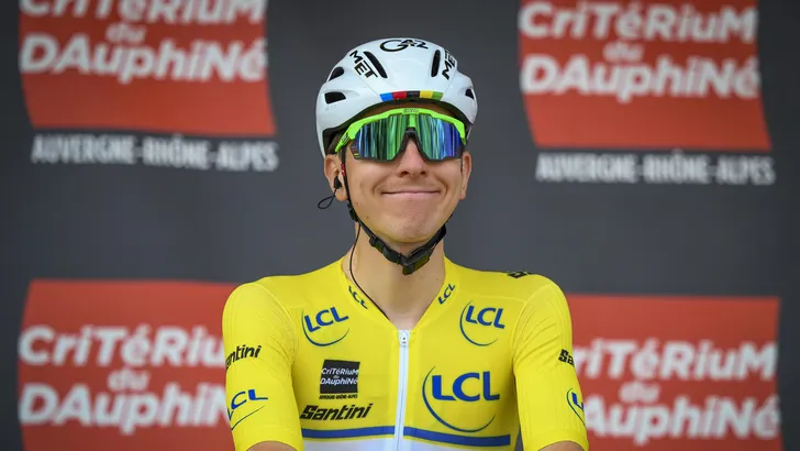 tadej pogacar voor een bord met criterium du dauphiné