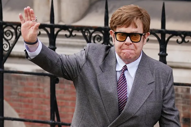 Elton John in pak, arriveert bij de rechtszaal voor de privacyrechtszaak. 