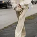 Stijlvolle vrouw met beige broek aan tijdens fashion week.