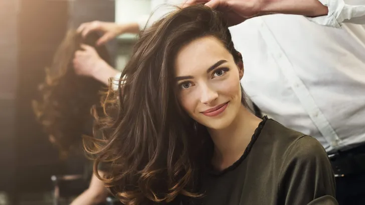 Woman sitting at beauty salon, making hairdo