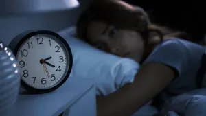 Depressed young woman lying in bed cannot sleep from insomnia. S