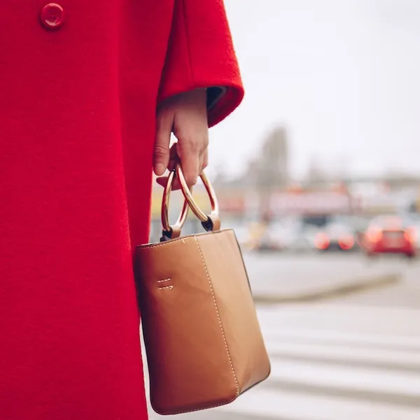 De Weekendtips van Beau Monde – Foto van vrouw met handtas en rode wollen jas.