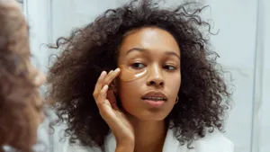 Foto van vrouw met skincare bij spiegel. – Skincare fout die voor wallen zorgt
