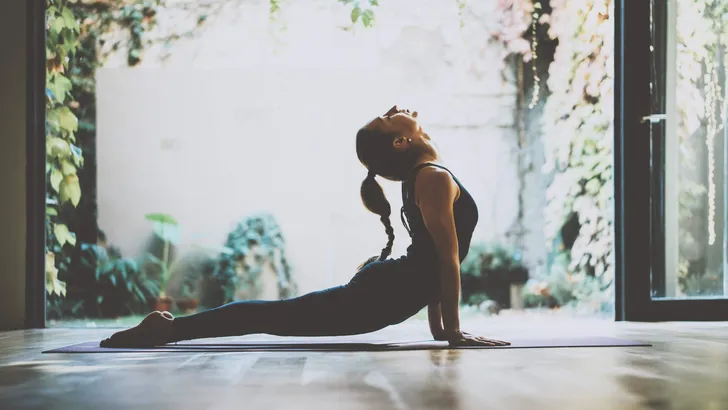 Portrait of gorgeous young woman practicing yoga indoor. Beautiful girl