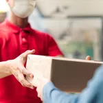 Asian postman, deliveryman wearing mask carry small box deliver to customer in front of door at home. Man wearing mask prevent covid19, corana virus affection outbreak. Social distancing work concept.