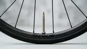 Close-up van een lage fietsvelg in een studio, waarbij het ventiel foutief en extreem ver (als een schoorsteen) uitsteekt.