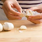 Woman peeling garlic by hand