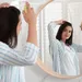 Vrouw spuit droogshampoo in haar haar.