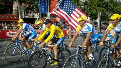 Armstrong met ploegmaats en Amerikaanse vlag op de Champs-Élysées