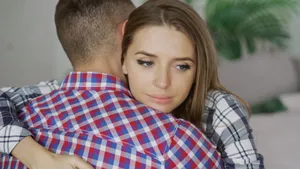 koppel knuffelt maar vrouw kijkt niet zo blij