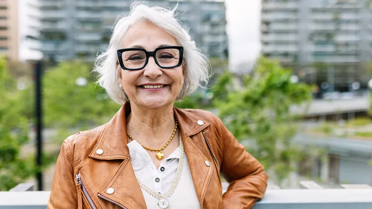 Vrouw met grijs haar en bril lacht