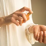 Classy look of young woman applying perfume