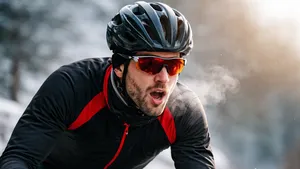 Wielrenner in winteroutfit met zichtbare adem die krachtig doortrapt op een koude winterdag, symbool voor het frisse ‘turbobenen’-gevoel na de kerstdagen.