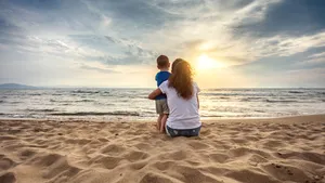 Mother with son enjoying sunset on the beach