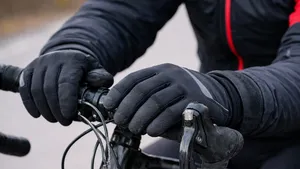 Fietser met dikke winterhandschoenen op een racefiets, handen op het stuur tijdens een koude rit