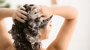 Vrouw wast haren onder de douche.