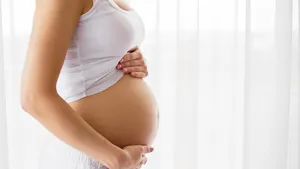 Pregnant woman standing next to window