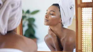 Perfect skin feels good. Cropped shot of an attractive young woman examining her face in the mirror at home.