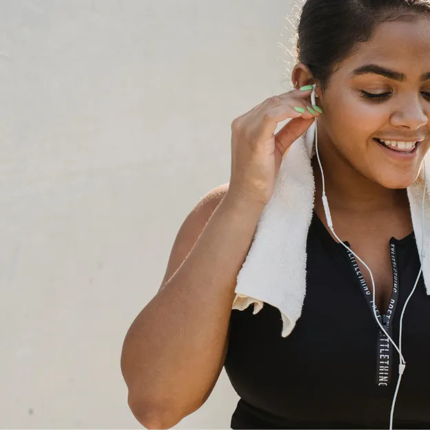 Smartphone vrouw met handdoek om nek en oortjes in