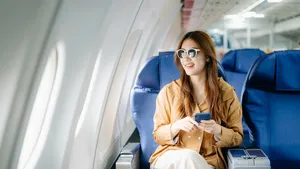 Foto van vrouw in vliegtuig. – Travel essentials voor comfortabele vliegreis