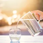 Pouring Water From Pitcher Into Glass