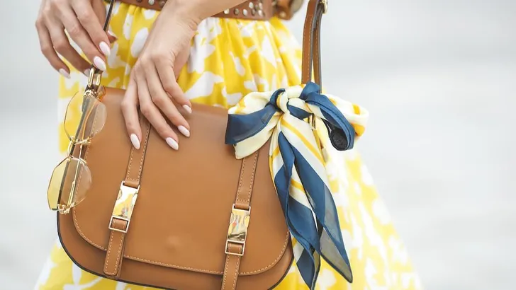 Women`s accessories. Female holding her purse close up.