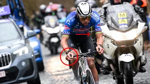 Actiefoto van Mathieu van der Poel op de kasseien, bewerkt met een rode cirkel om zijn knie en een rode pijl bij zijn onderrug om de biomechanische asymmetrie en fysieke belasting te illustreren voor Wieler Revue.