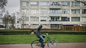 Sfeerbeeld van de Utrechtse Wijk Overvecht; een langsrijdende fietser steekt zijn middelvinger op