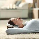 Relaxed woman listening to music with headphones at home