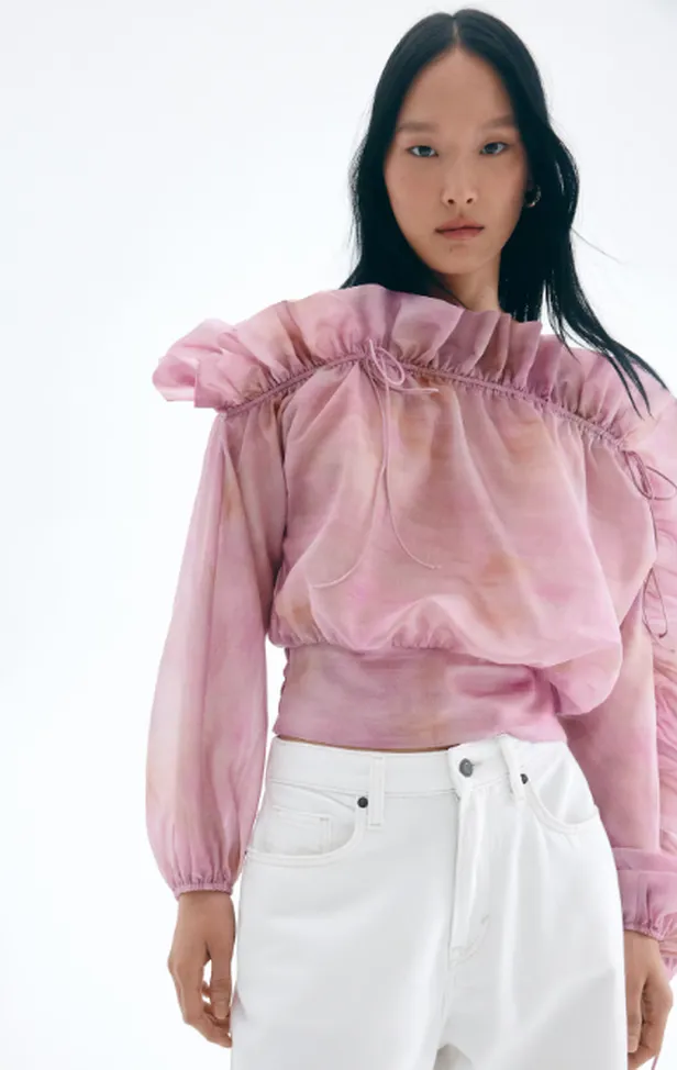 Model in roze asymmetrische blouse van H&M