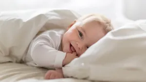 Cute happy 7 month baby girl in diaper lying and playing