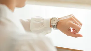 Vrouw kijkt op horloge om haar pols om de tijd te controleren.